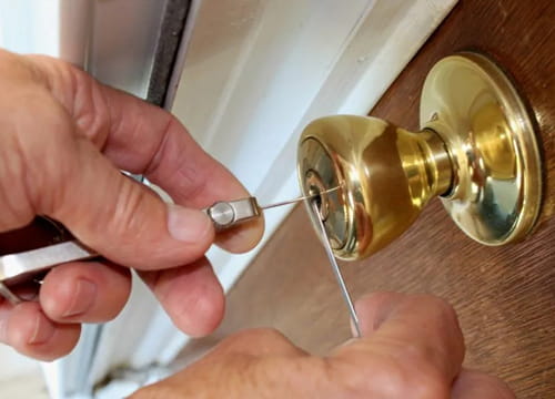 Locksmith assisting with a house lockout using lock picking